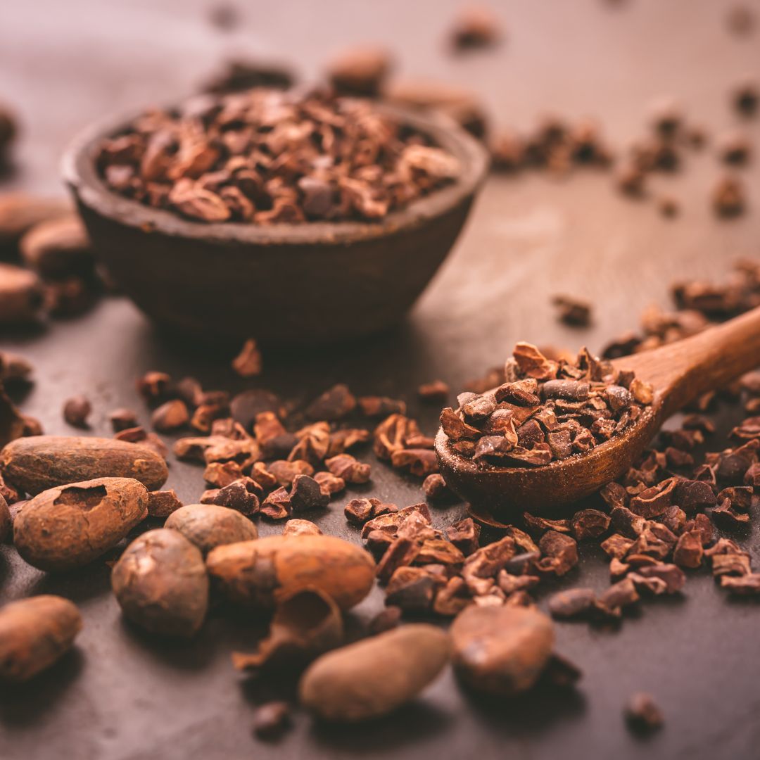 Close-up of cacao nibs and beans, showcasing their rich, earthy texture and deep chocolatey aroma, perfect for tea blends and energy-boosting recipes.