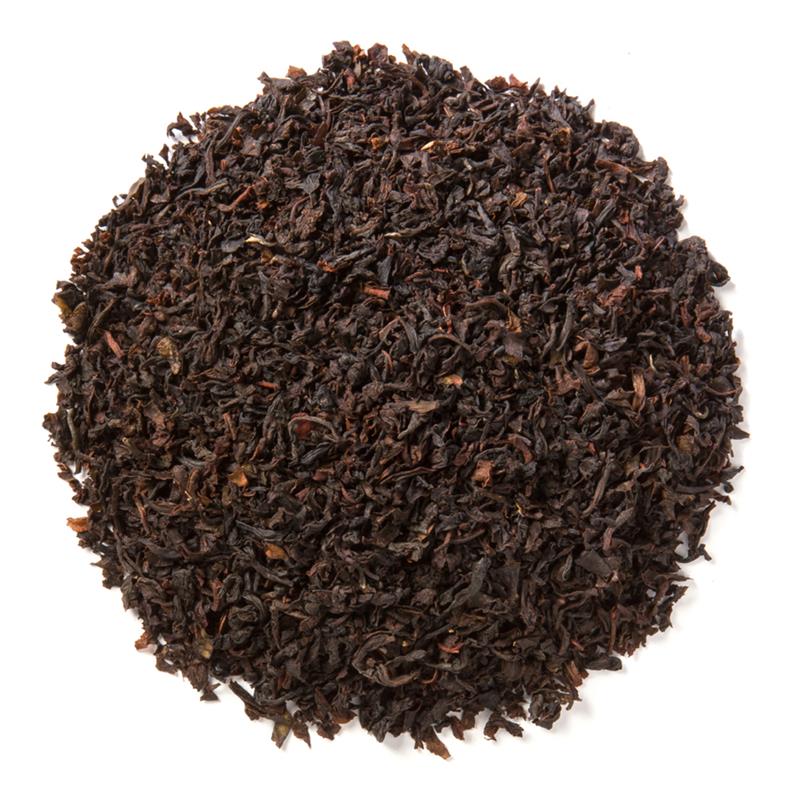 A close-up of Orange Pekoe (OP) tea leaves, showcasing their long, unbroken structure and smooth appearance, ideal for light and balanced brews.