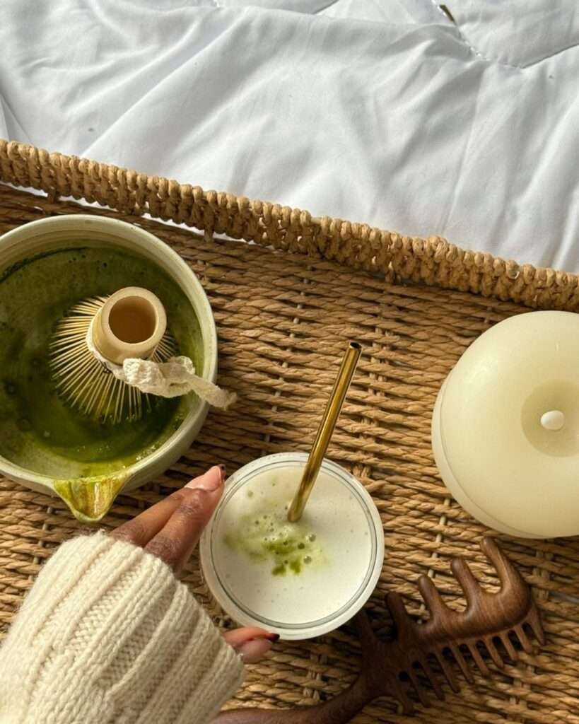 Freshly whisked matcha latte on a woven tray with tea tools, representing a focused morning tea ritual.